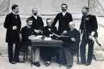 ｜アテネでのオリンピックの第1回委員会でのクーベルタン（座ってペンを持つ人）、1896年