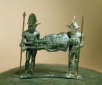 ｜負傷した仲間を運んでいる2人の兵士の形をしたキスタ（円筒形容器）の取っ手